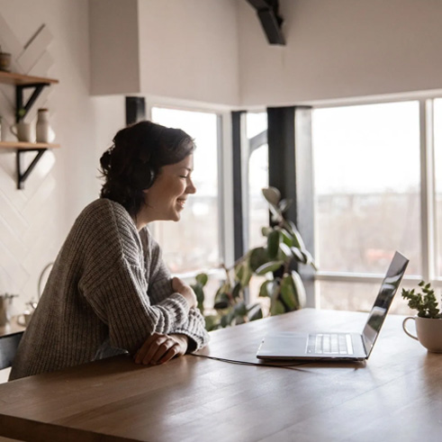 Woman using computer in kitchen