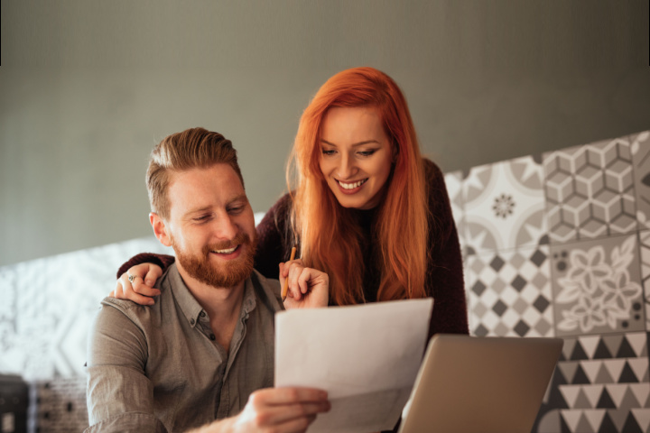 couple looking at bills with laptop