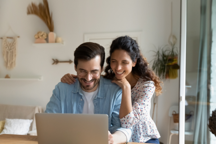 Man and woman smiling at laptop