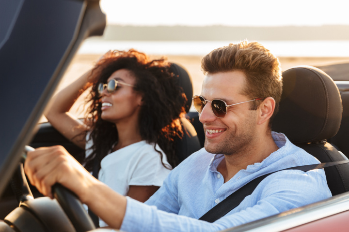 Man and woman riding in a convertible