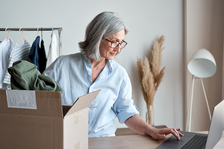 female clothing store owner by laptop