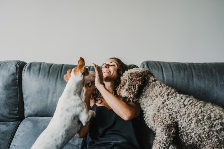 woman on couch with two dogs