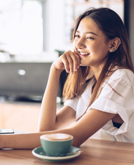 Smiling woman sitting at table with a latte