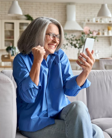 excited woman looking at cell phone