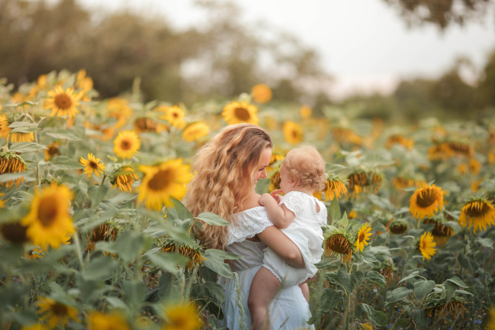 Woman and baby in sunflower field