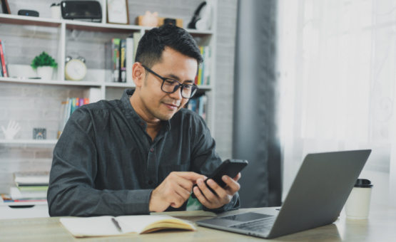 Asian man looking at cell phone