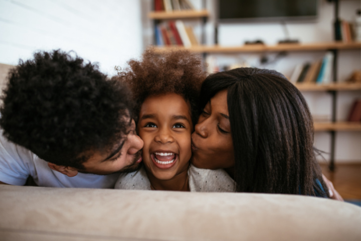 parents kissing their child