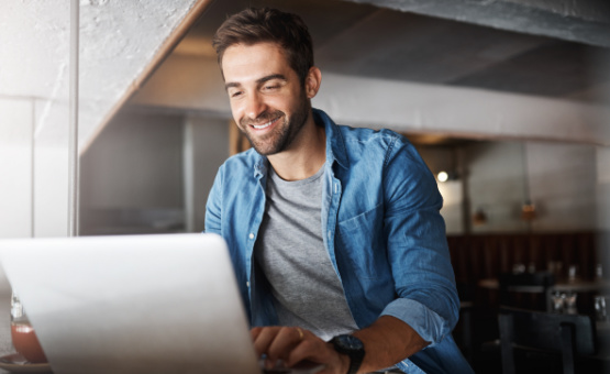 smiling man sitting by laptop