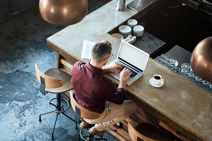 Man sitting at counter using laptop