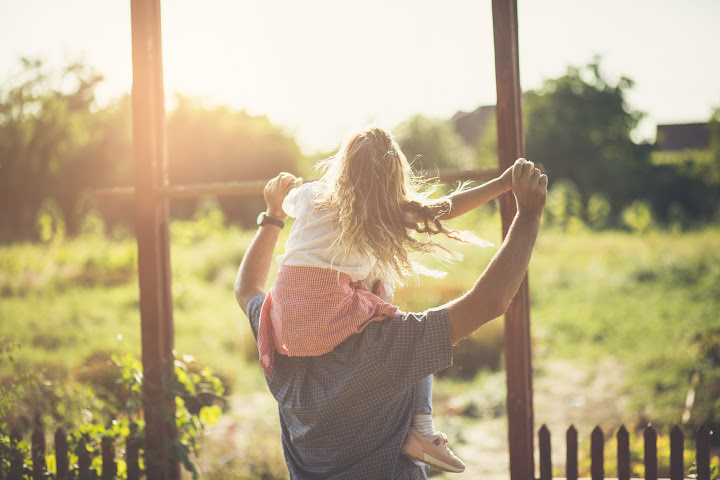 small girl on dad's shoulders