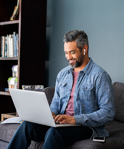 smiling man looking at laptop