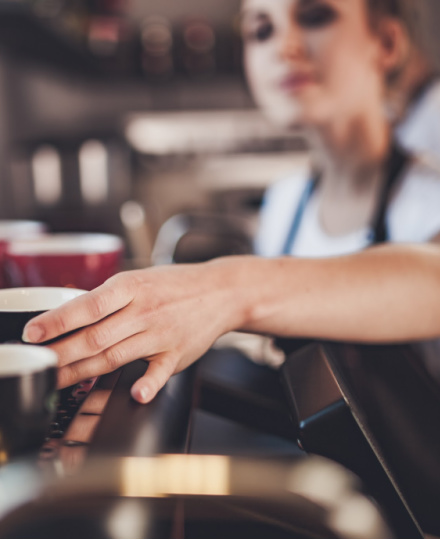 woman making coffee at a coffee shop