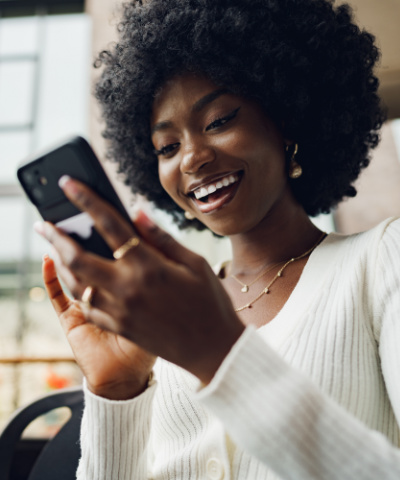 smiling woman looking at cell phone