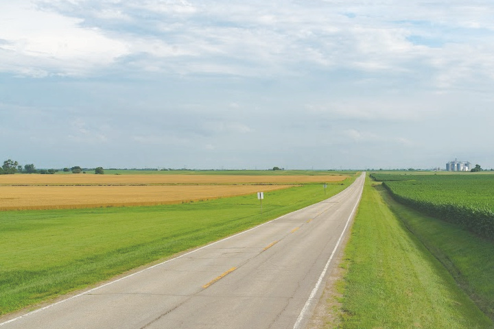 paved county road next to a field