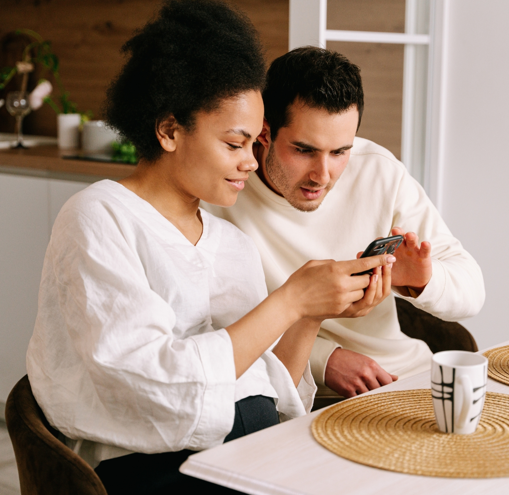 man and woman looking at cell phone