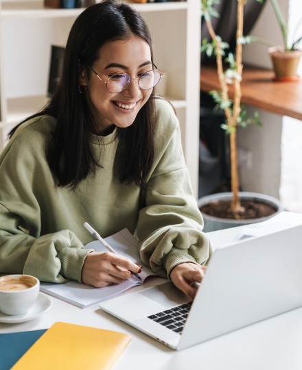 smiling woman looking at laptop