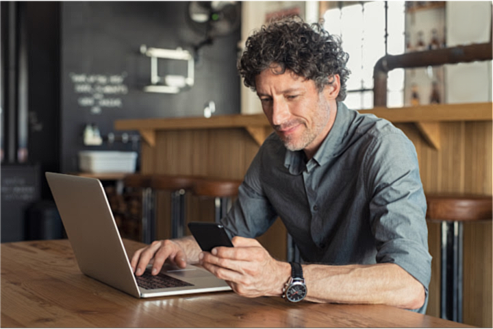 male restaurant owner sitting by laptop