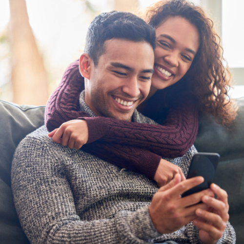 happy couple looking at cell phone