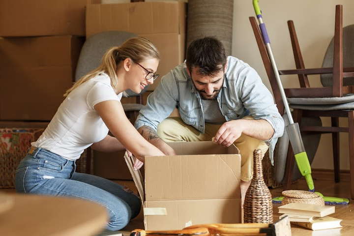 man and woman unpacking moving boxes