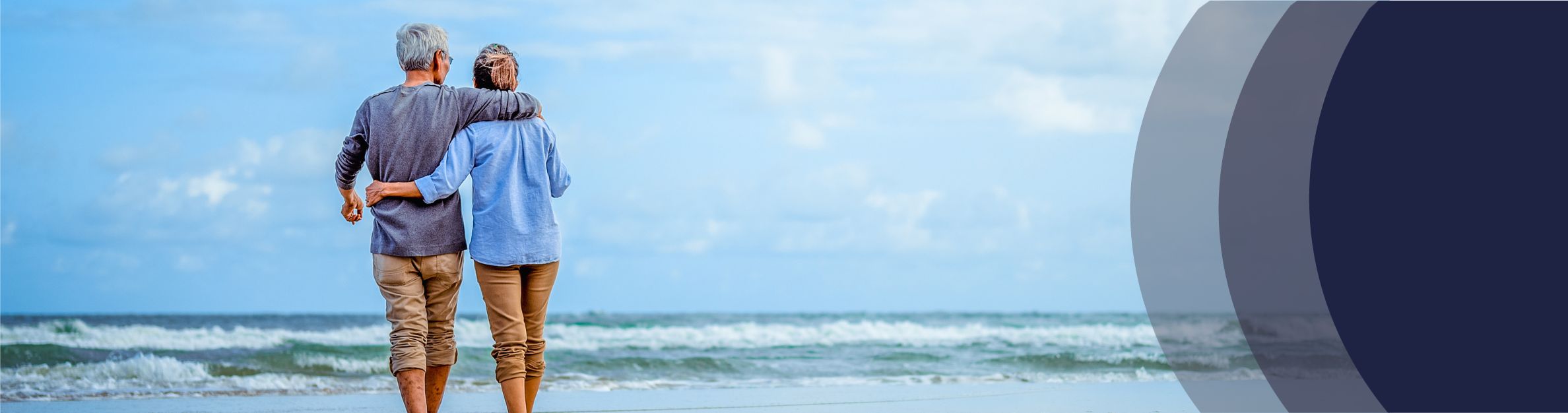 a mature couple walking on the beach